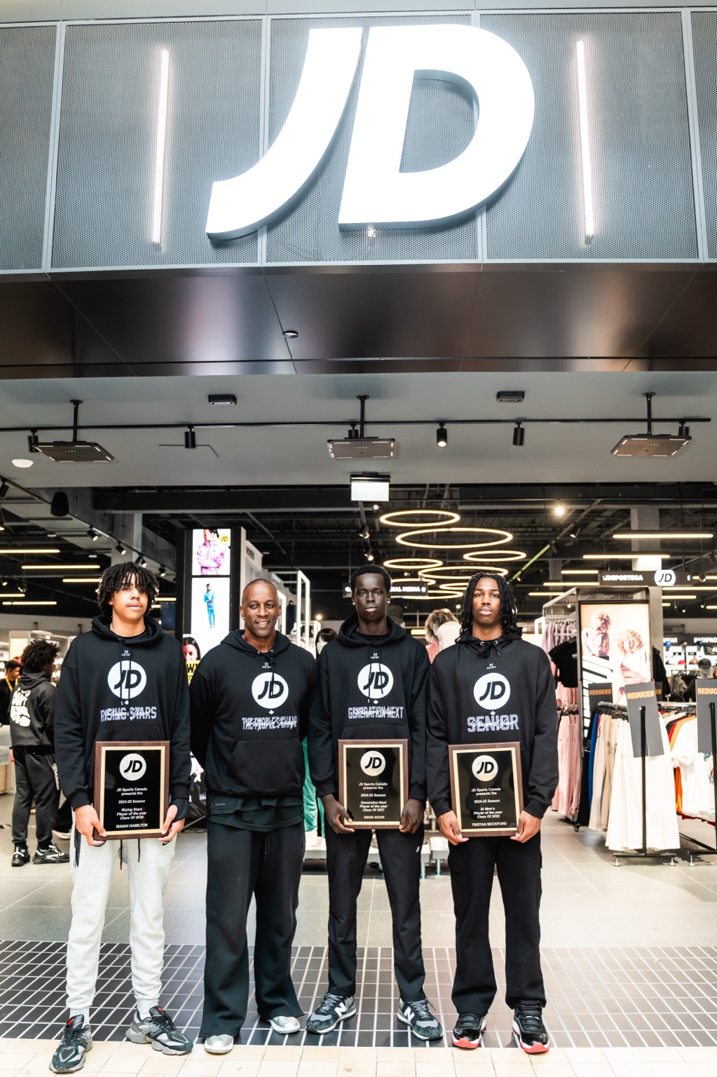 JD Sports Canada activation participants holding recognition plaques in store